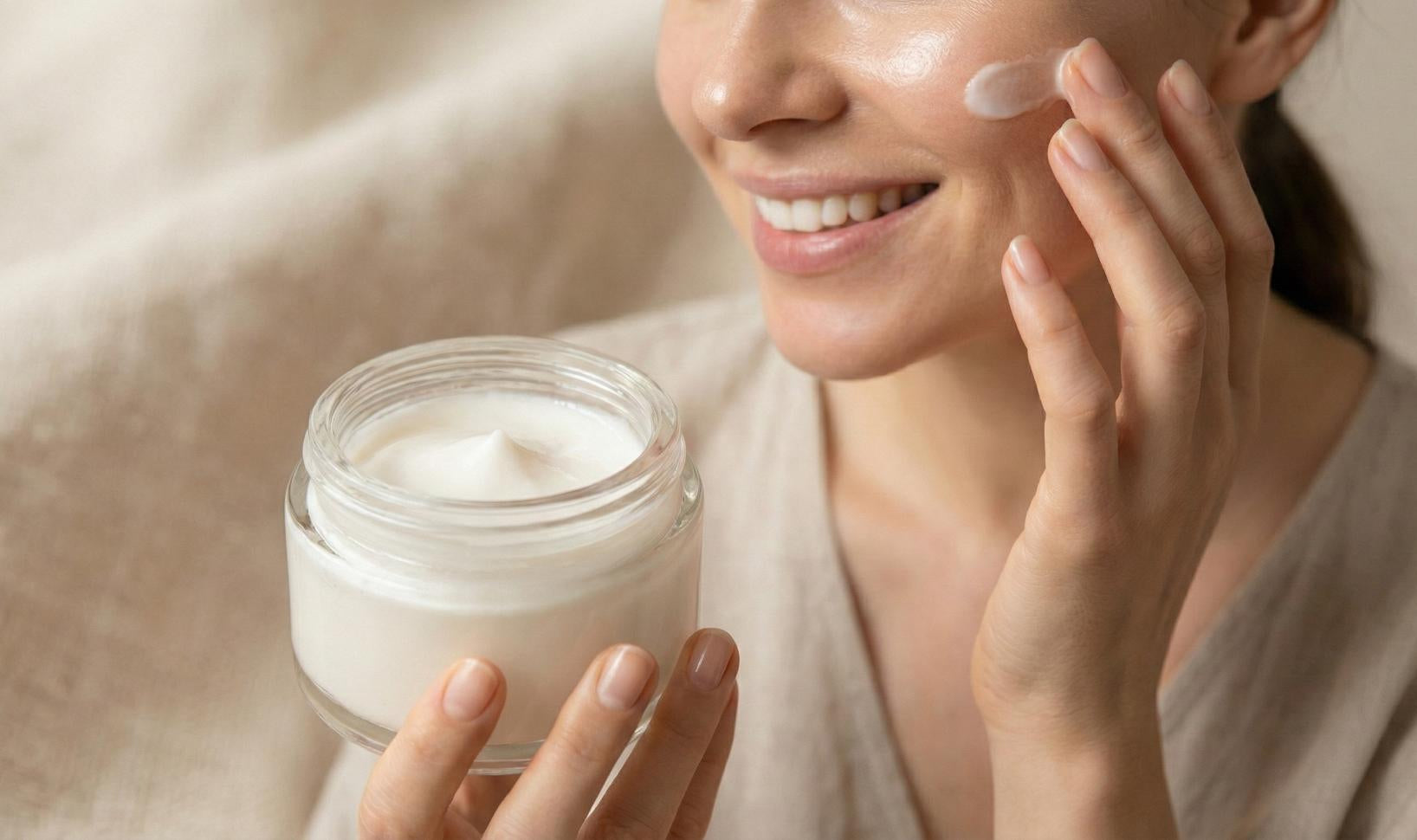 Donna con pelle luminosa che applica una crema viso coreana effetto lifting per migliorare elasticità e tono. Boramori